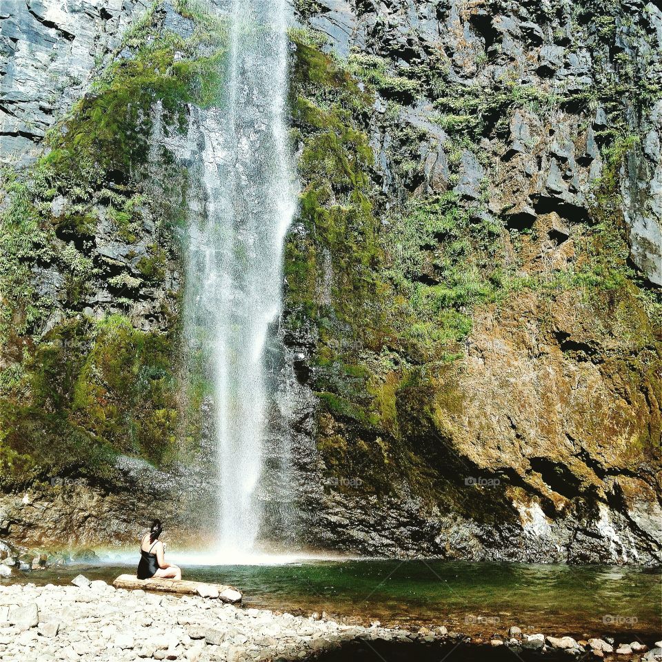 A woman enjoys a waterfall in Gifford Pinchot National Forest, Washington.