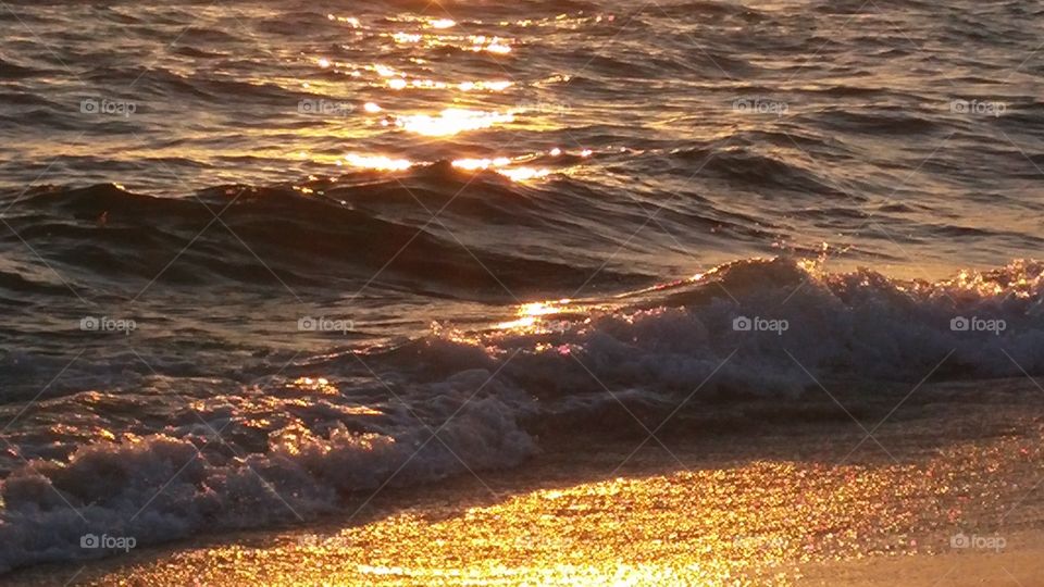 Sunset at the beach with close up of waves