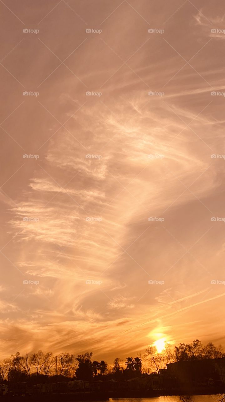 High Clouds adjusting the sky during Sunset. Colors radiating within all the feathering of clouds with wind patterns. 