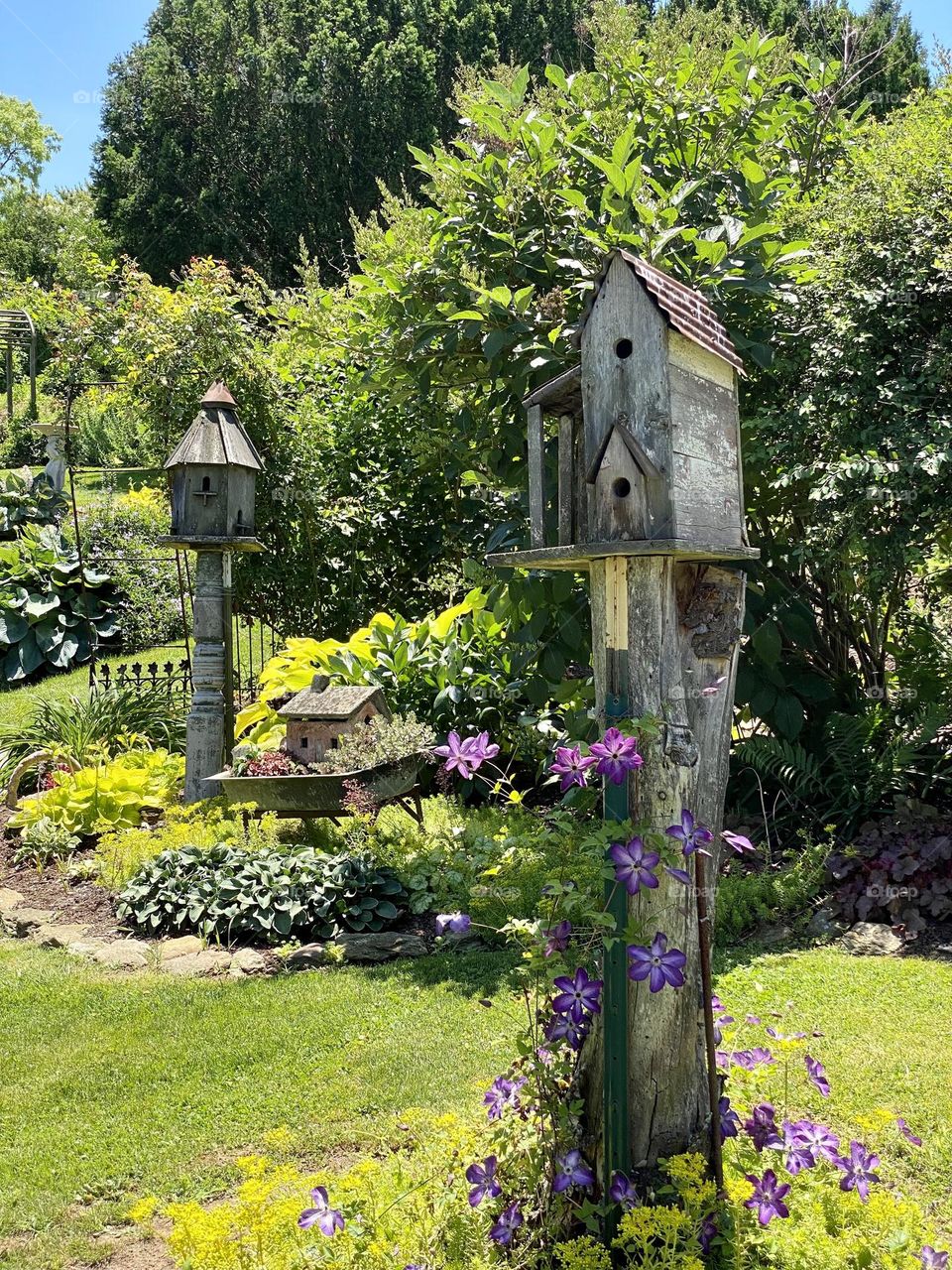 Two wooden birdhouses in a beautiful garden