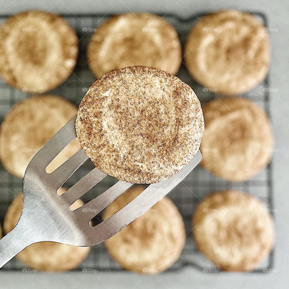 Making Snickerdoodles at home, making cookies from scratch, delicious cookies made at home, Snickerdoodle cookie recipe, taking cookies out of the oven, cookie on a spatula, delicious treats made from scratch 