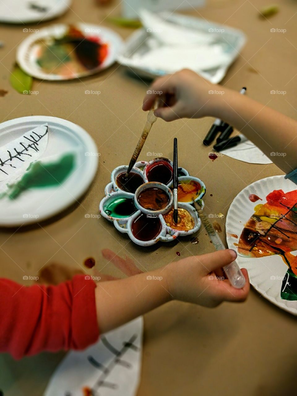 Small child crafts leaves for a tree