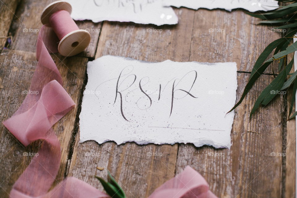 Graphic arts of beautiful wedding calligraphy cards with pink chiffon bobbins on wood background