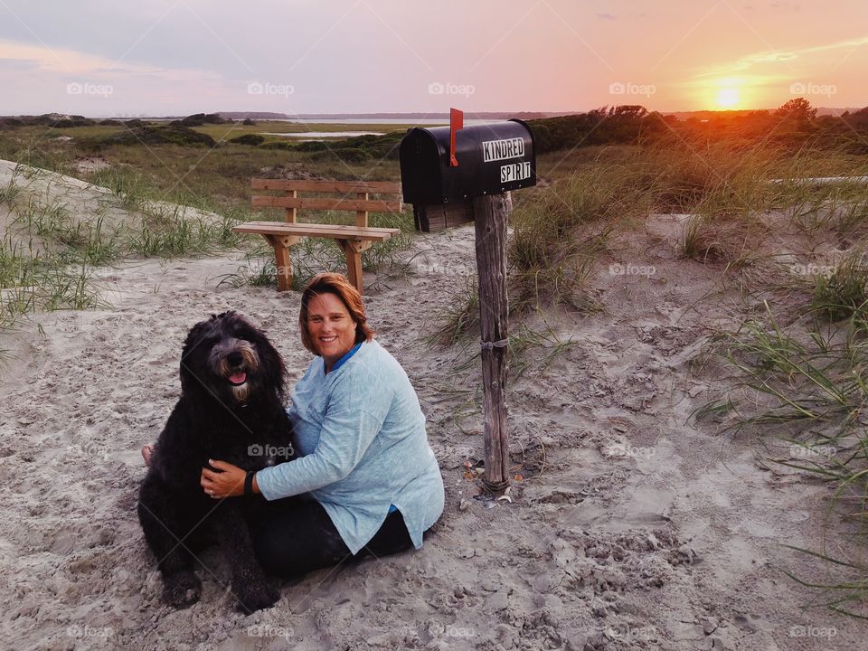 Owner and service dog doing some soul searching on the beach at the Kindred Spirit Mailbox in North Carolina. Mailbox is the basis of Nicholas Sparks upcoming book this fall.