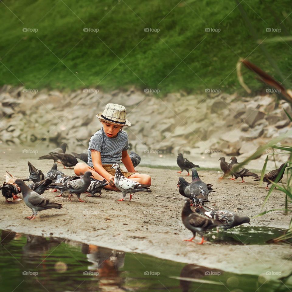 Boy is sitting with birds