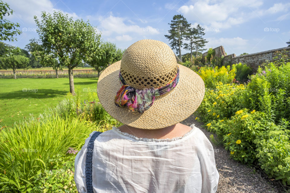 Rear view of woman wearing straw hat in the garden