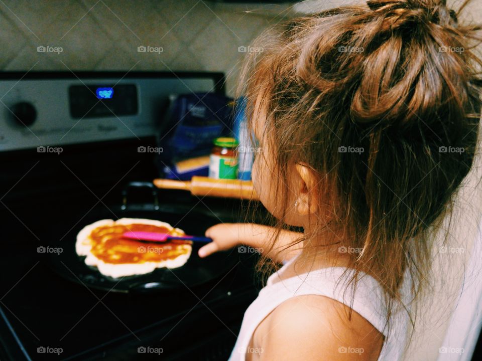 Rear view of a girl preparing food in kitchen