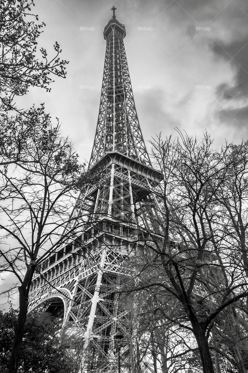 B&W Eiffel Tower, it’s point disappearing into the cloudy winter Paris sky.