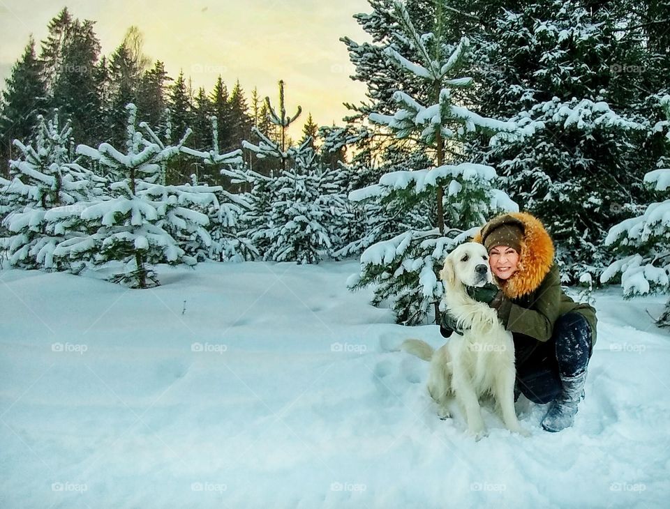 Smiling woman with her dog during winter