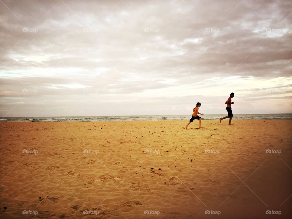 Kids running in a beach at the end of the day