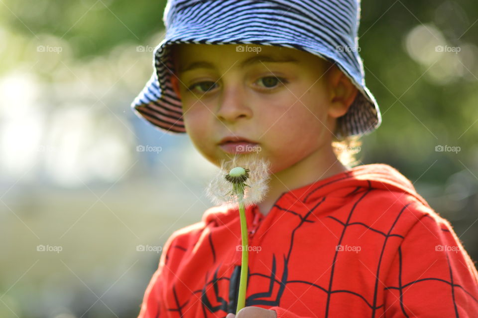 Close-up of boy with dandelion
