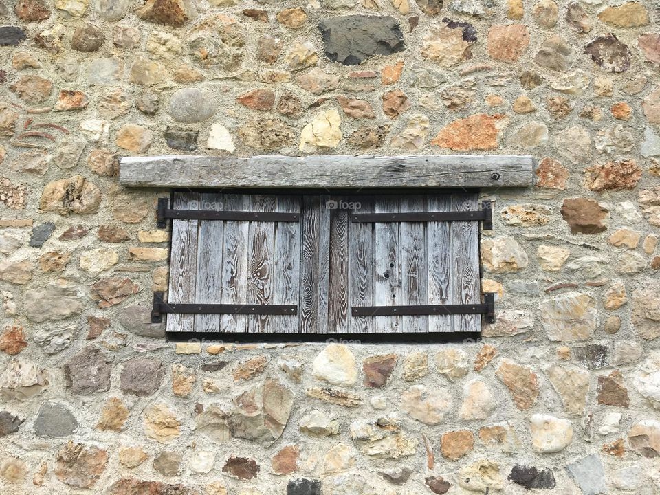 Closed wooden shutters and stones wall