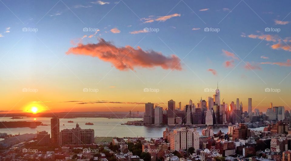 The amazing view of downtown Manhattan from Brooklyn, NY at sunset time. Watching the skyscrapers on the right and the Statue of Liberty on the left, while the sun says “goodbye and see you tomorrow “