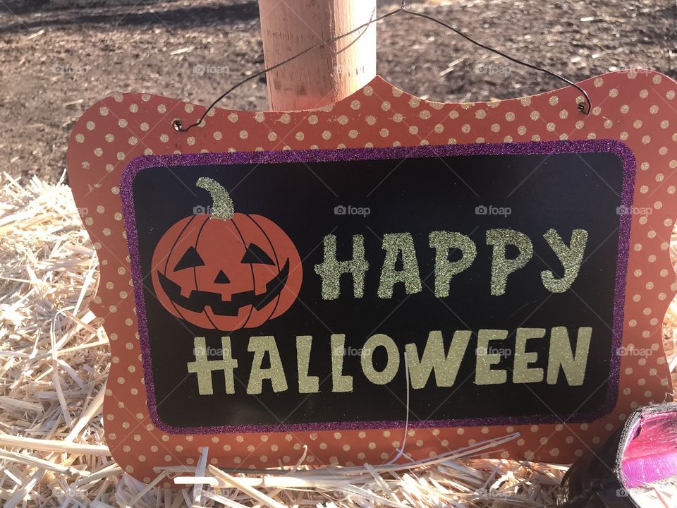 A bright and colorful Happy Halloween sign welcoming guests at the pumpkin patch in America, USA 