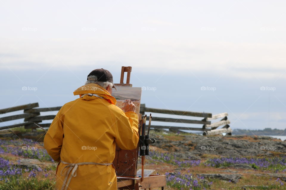 Amateur painter painting by the ocean 