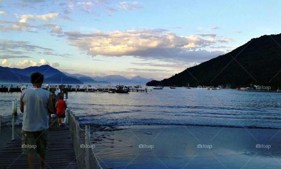 As pessoas no cais observam as belezas das paisagens.