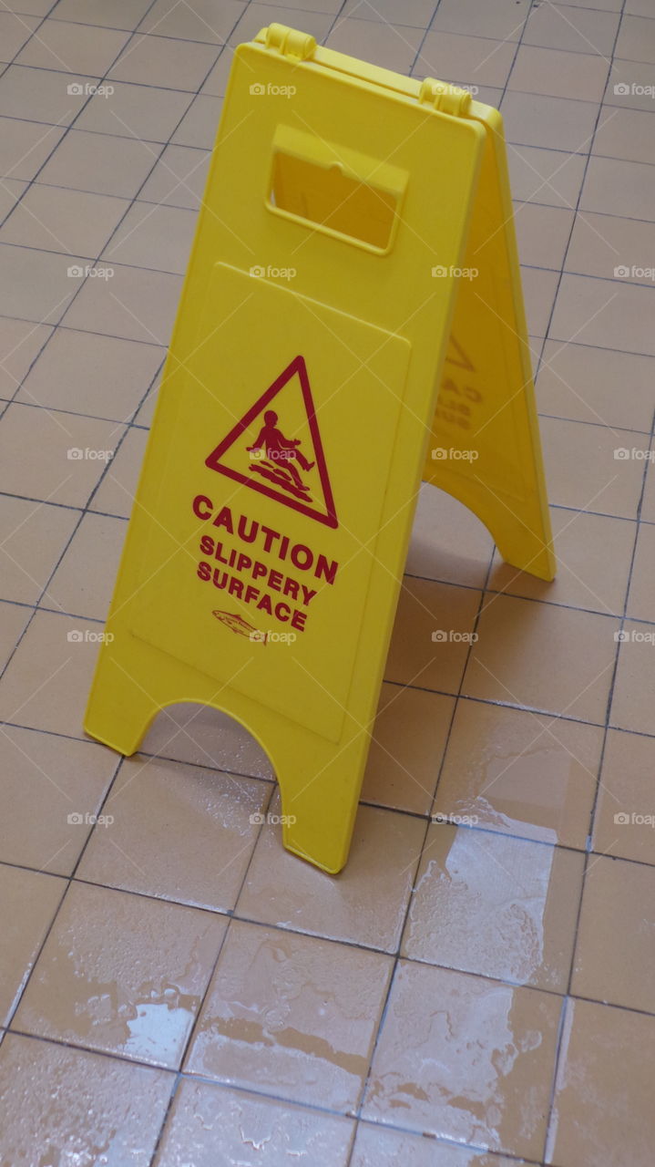yellow folding caution slippery surface warning sign. salmon product