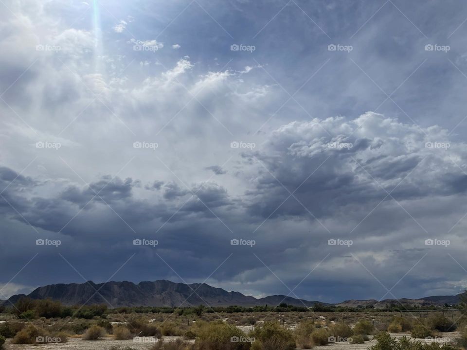 Dark grey and blue clouds with mountains.
