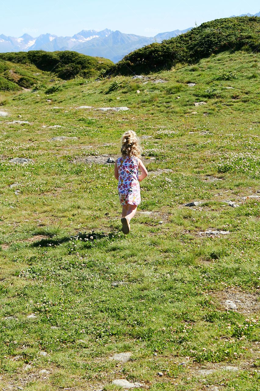 Child walking at an moutain meadow.