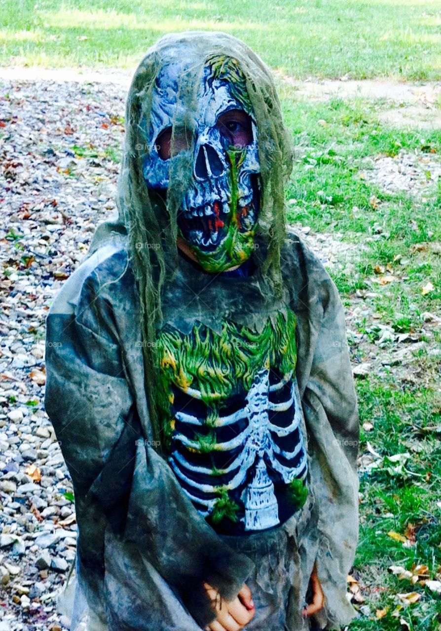 Child dressed up for Halloween green slimy skeleton 