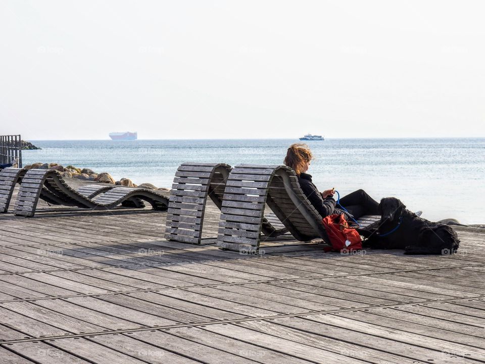 Girl with black dog on a sunny day at the coast in Helsingborg, Sweden.