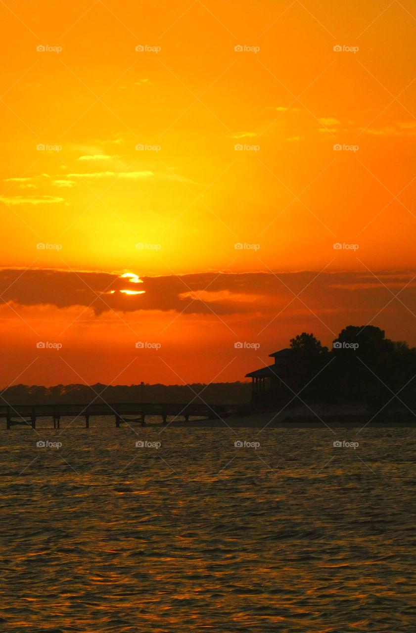 Blushing sunset peeks from behind the cloud cover!
The bay is basked in a liquid gold by the rays of the spectacular sunset!