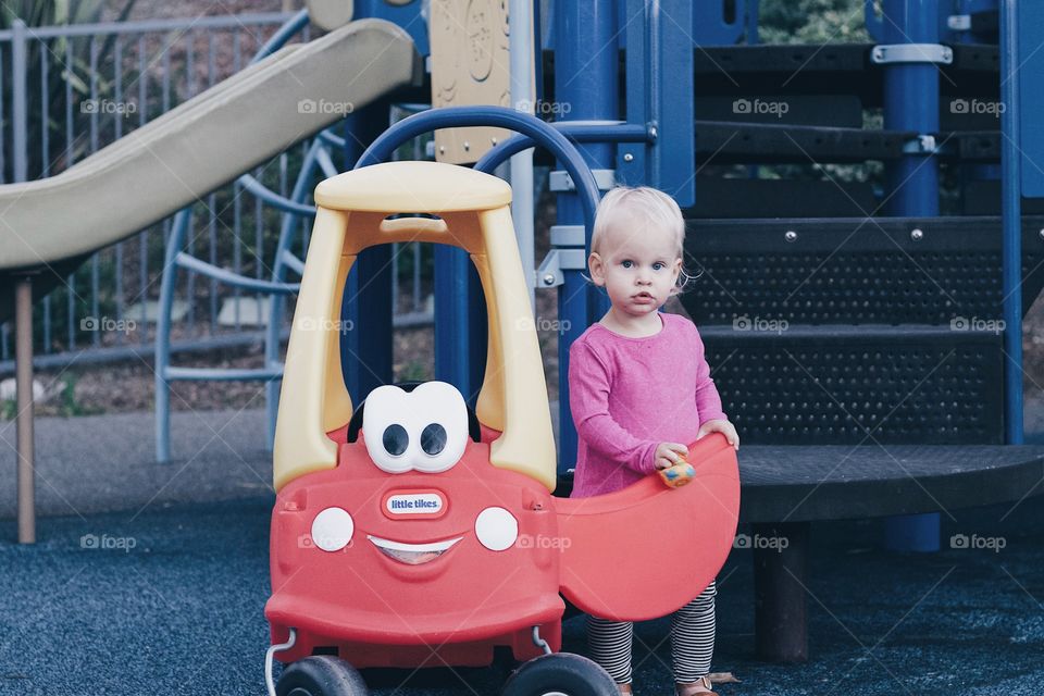 Toddler with toy car at playground