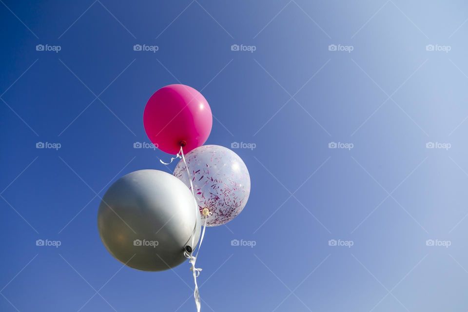 Three helium balloons in the sky