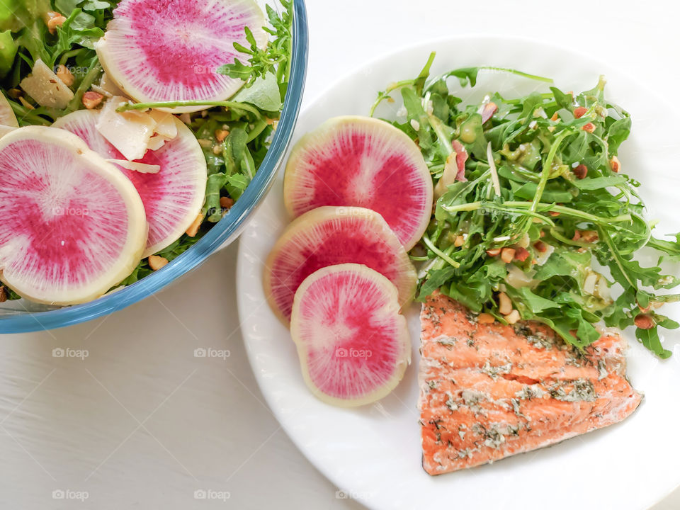 Salmon with lemon aragula salad and watermelon radishes on the side.