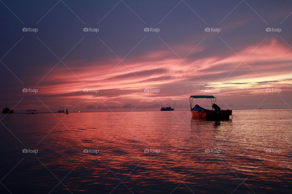 Golden hour in Koh Tao, Thailand. A beautiful colourful sunset, you can feel the peace and the local customs. Small boats.