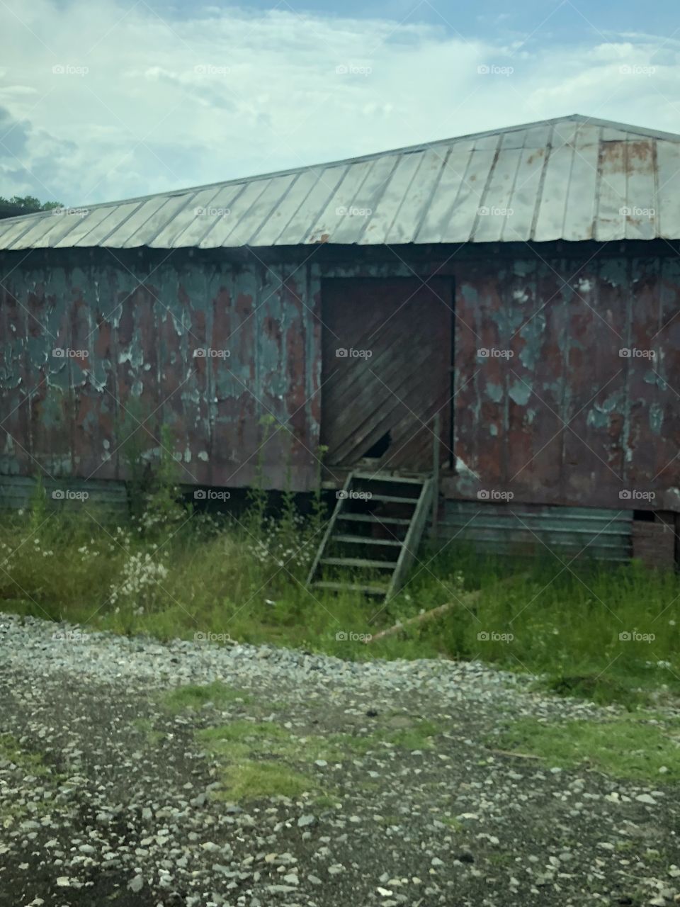 Very old building in the countryside  with tin roof. 