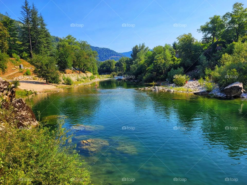 Scenic view of green Alps mountains against blue sky and beautiful lake in Slovenia. Summer time. Vacation. Landscape