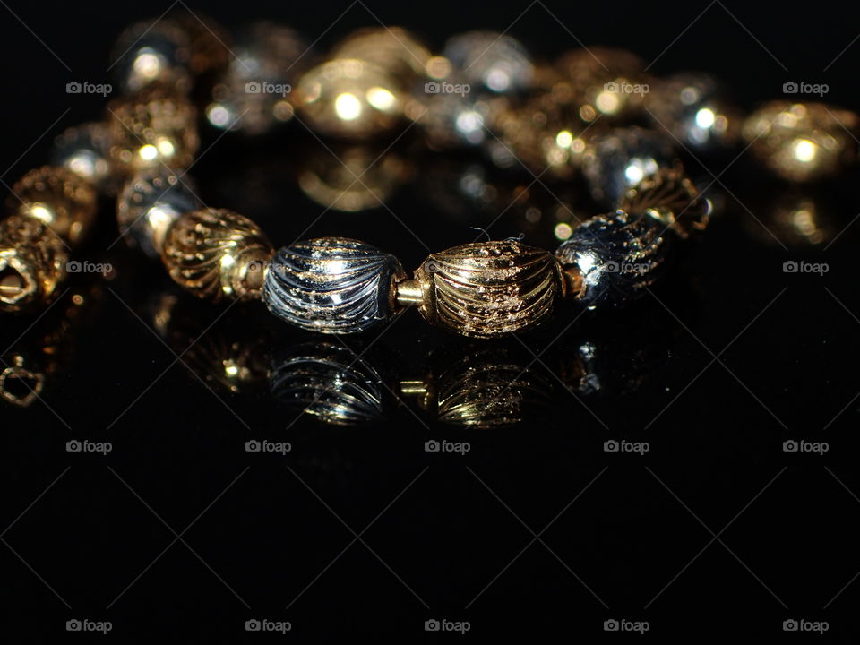 Gold bracelet on reflective surface