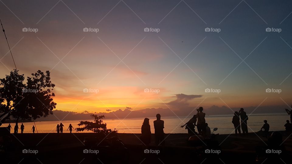 silhouettes of people during a sunset on a beach in bali