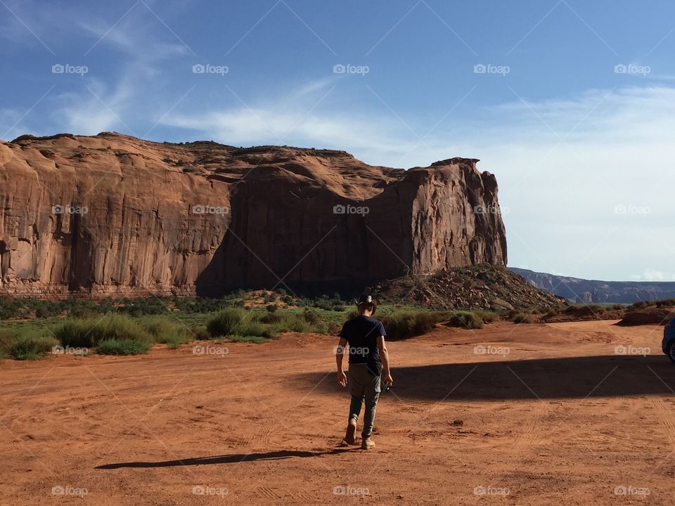 Man walks in the desert of the monument valley 
