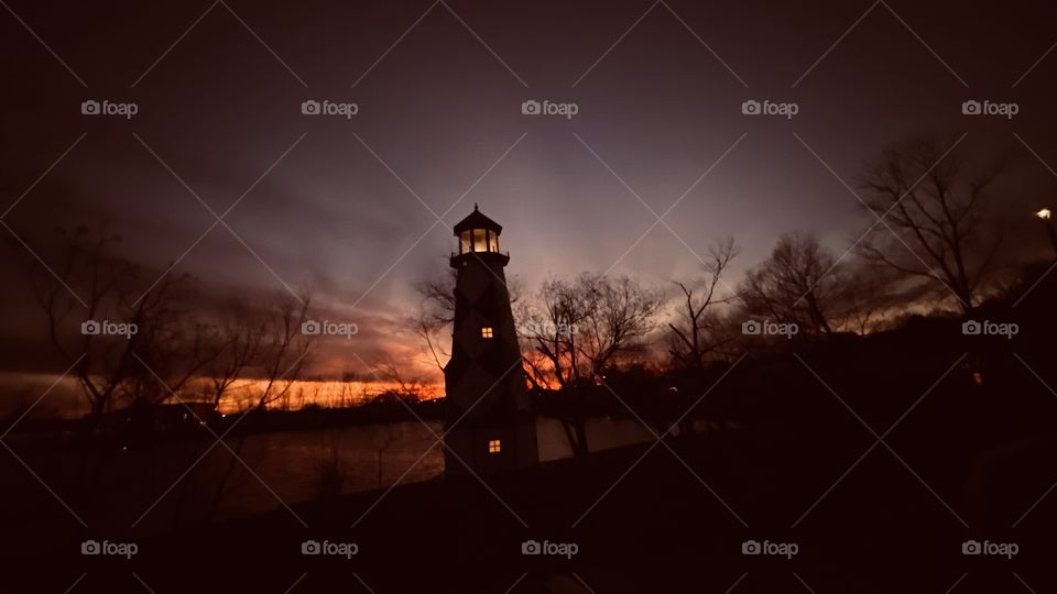 As the Atmosphere cools the Sky turns a Gorgeous Green with Red And Pink Hues still having bit snd pieces of Red Orange Clouds. Majestic Lighthouse Centerpoint of the Twilight to Night Feature.