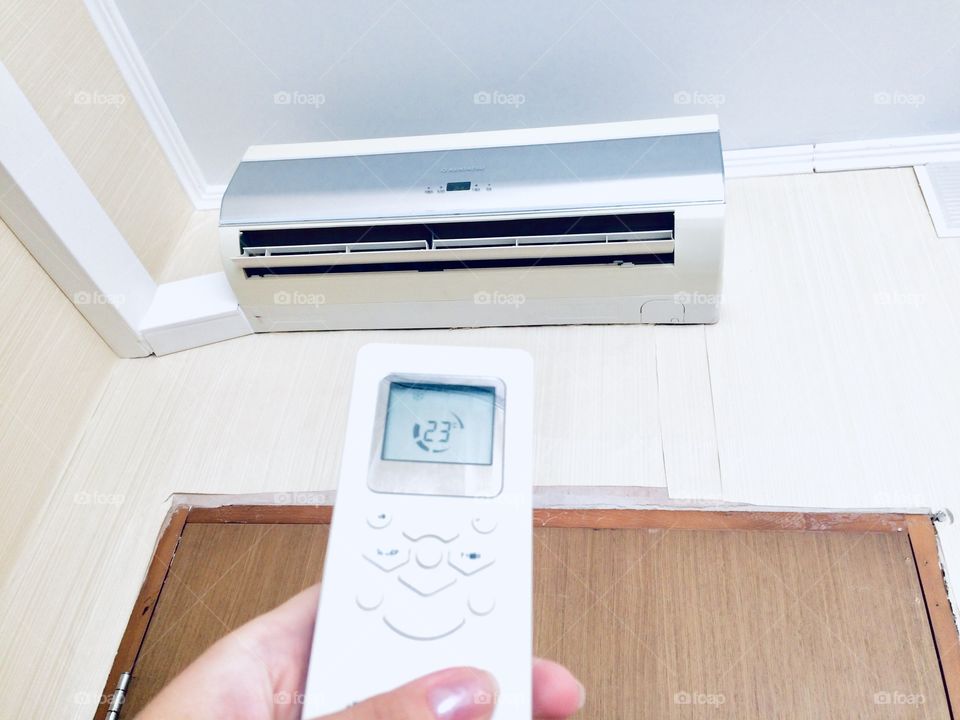 Hand on the air conditioner remote controller cool