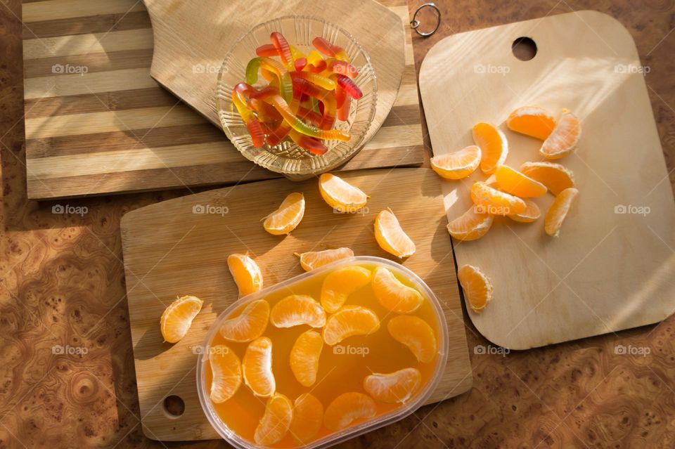 Delicious orange jelly with tangerine slices in a container and jelly worms.