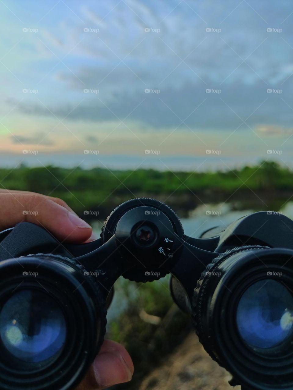 Hand man hold binoculars on a beautiful day on the river, binoculars sailor