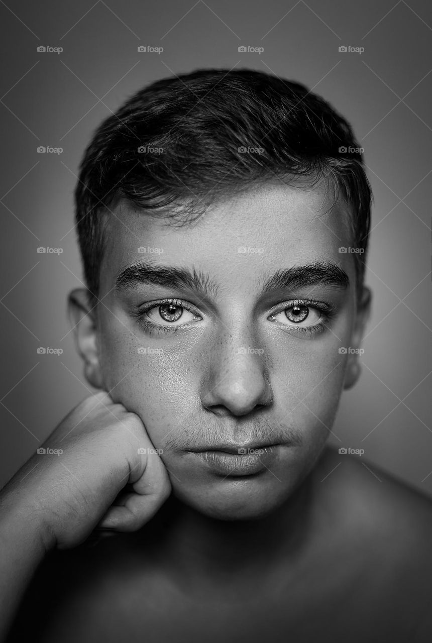 Close-up portrait of shirtless boy looking at camera .