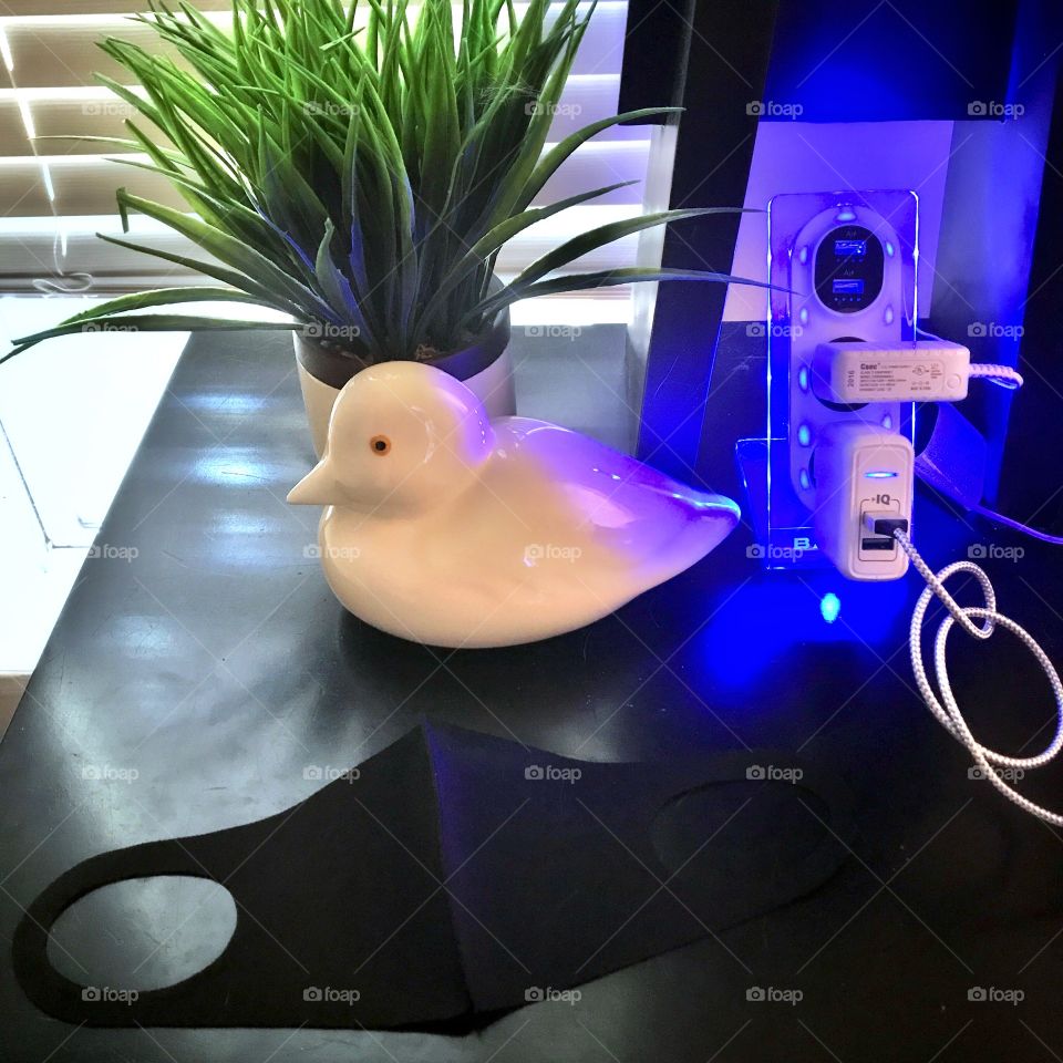 It has gotten customary to have my mask by my bed for easy reach. Black face mask on a black night stand.