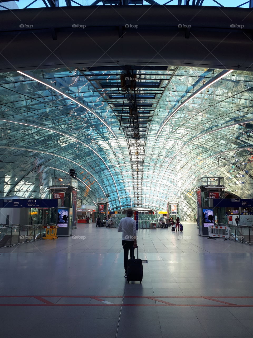 Airport terminal with glass roof. Man go with bag in the airport