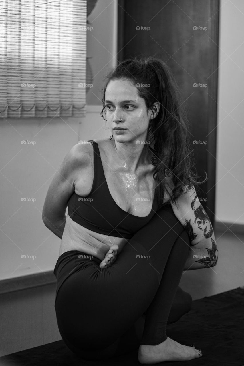 mulher realizando posição de yoga em preto e branco.