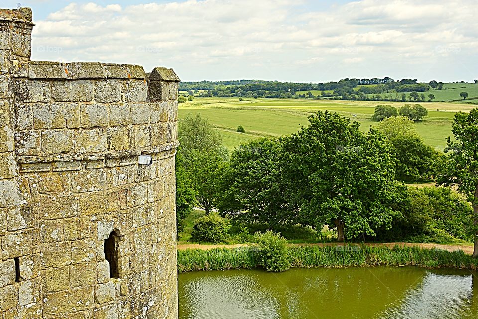 Bodiam Castle turret, with rolling East Sussex countryside in the background.