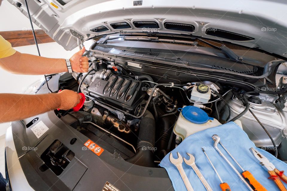 Mechanic gives thumbs up as car is fixed and ready to use