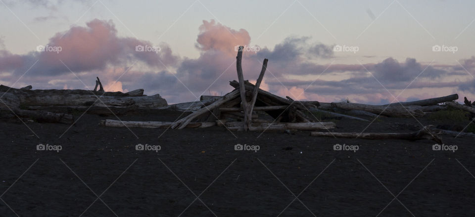 A longhouse style beach fort on City Beach in Ocean Shores at sunset.
