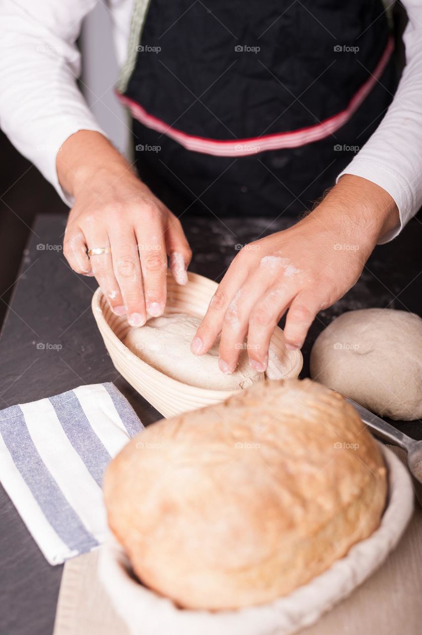 Placing sourdough in baking tray. Baking bread at home.