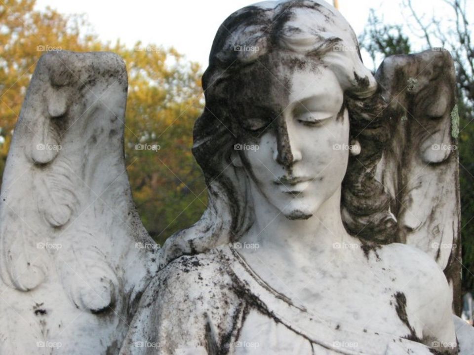 Blackened cemetery angel statue.