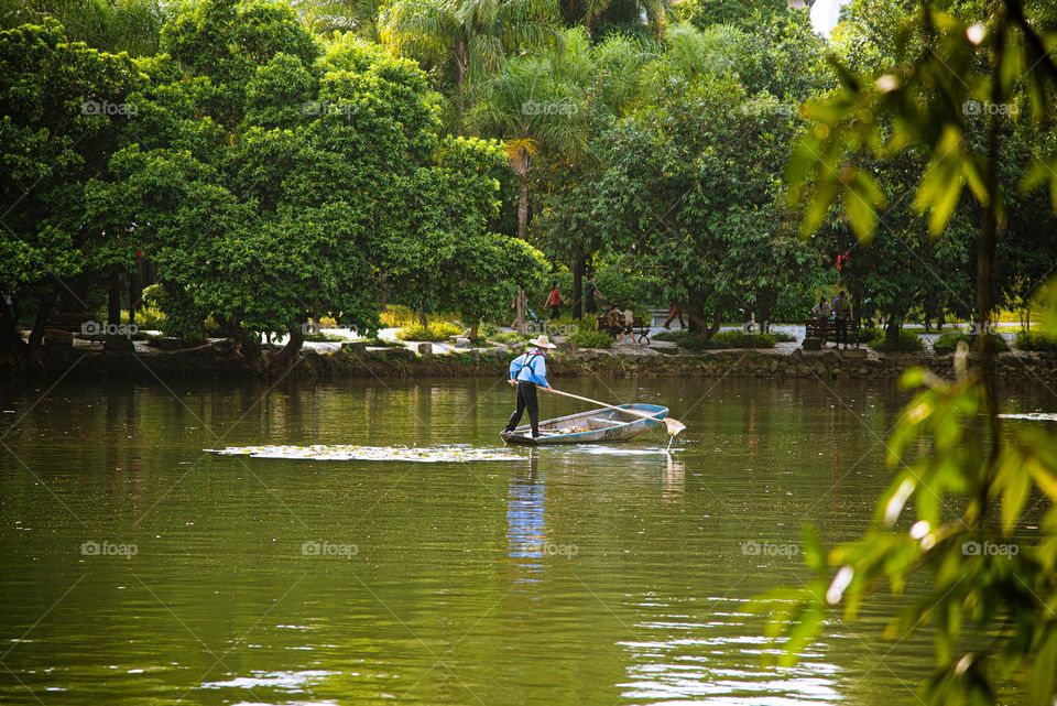 A man is collecting unnecessary things from the lake.