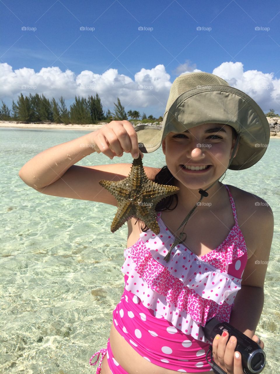Happy girl holding star fish